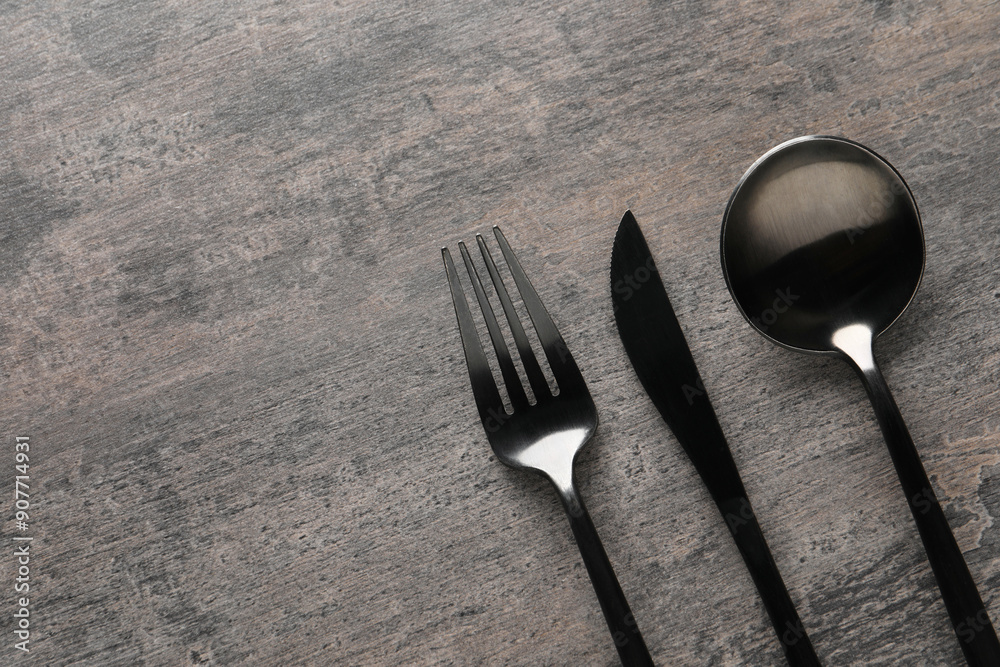 Wall mural Stylish cutlery on grey table, flat lay. Space for text