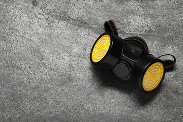 One respirator mask on grey table, top view. Space for text