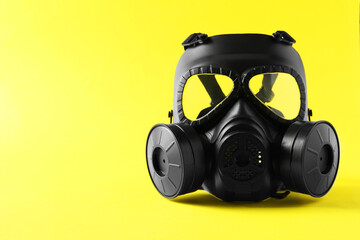 One gas mask on yellow background, space for text. Safety equipment