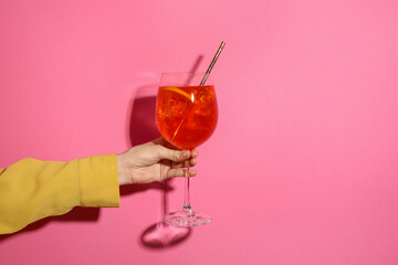 Woman with glass of refreshing cocktail on pink background, closeup. Space for text