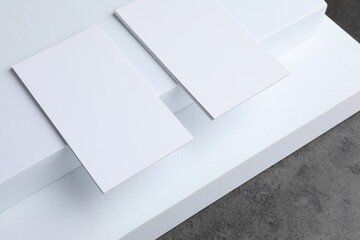 Blank business cards on grey textured table. Mockup for design