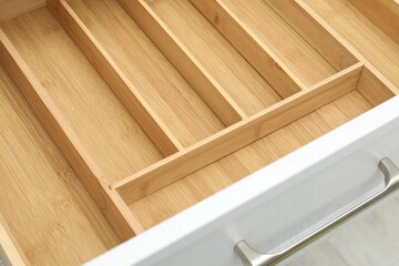 Open drawer of kitchen cabinet with space for cutlery, closeup