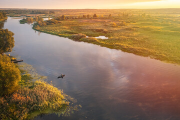 A serene river landscape at sunset, featuring lush greenery and stunning water reflections