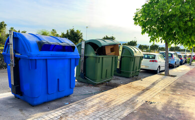 Dumpster for Garbage. Litter, food waste on city Spain street. Dumpster and trash container. Plastic bags, packaging waste in garbage container. Trash, Household waste. Overcrowded garbage.