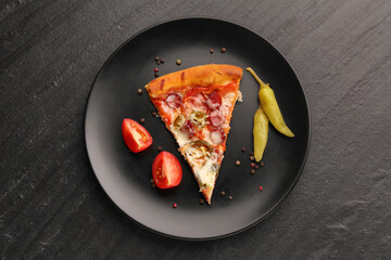 Plate with delicious pizza Diablo, pepper, tomato and peppercorns on dark textured table, top view