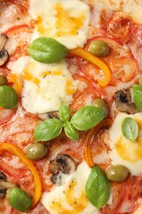Delicious vegetarian pizza with basil as background, closeup