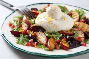 Plate with fresh burrata salad on white wooden table, closeup
