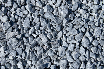 Gray small rocks ground texture. black small road stone background