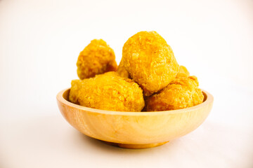 Tahu goreng cripsy, or crispy fried tofu, is one type of snack in Indonesia on wood plate isolated on white background. Perfect for recipe, article, catalogue, commercial, or any cooking contents
