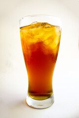 Iced tea with lemon and ice in a tall glass on a white background. The concept of a refreshing drink or lemonade on a hot summer day. Front view and copy space.