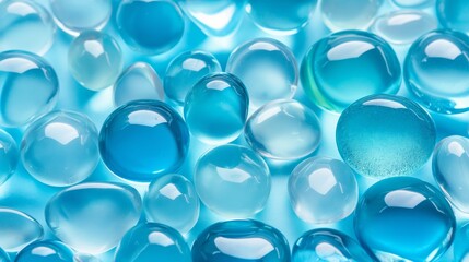 A collection of blue glass beads on a blue background. The beads are all different sizes and shapes, creating a visually interesting and dynamic composition