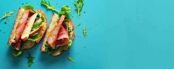 Honey drizzled pear and ham sandwich on a blue background. Free copy space for text.