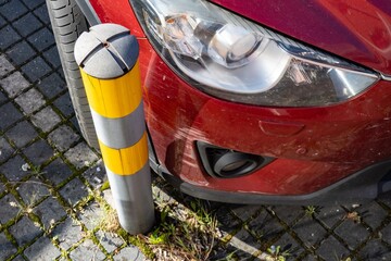 Red car scratched when parking near pole