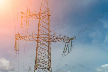 Fototapeta premium High voltage towers with sky background. Power line support with wires for electricity transmission. High voltage grid tower with wire cable at distribution station. Energy industry, energy saving