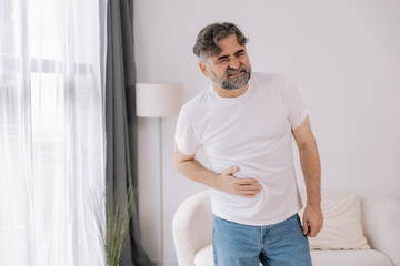 Elderly man suffering from digestive problems, liver and gall bladder problems and intestinal pain...