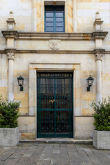 Entrance to a building in rich colonial style, with green bars on the doors