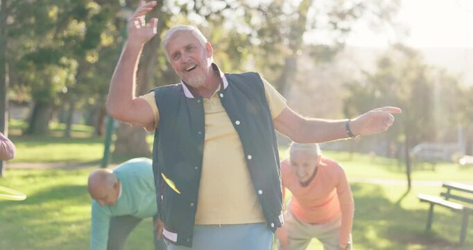 Senior man, hoop and park with group for exercise class, fun workout or elderly care in fitness. Happy, mature male person or people with toy for movement, balance or stretching muscle in nature