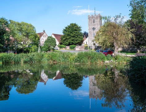A reflection of St Mary's church tower in Buriton pond on a bright summer afternoon.
