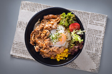 Japanese beef hot spring egg rice bowl with corn and salad served in bowl isolated on napkin top view of chinese food on grey background