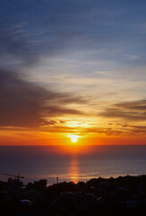 clouds illuminated by the rays of the sun, dawn over the sea, orange clouds, dawn on the coast of the city