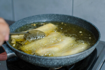 Fried banana in a pan with hot oil and spatula. Banana deep fried is a popular street food in Indonesia
