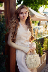 a  beautiful teenage girl in a peach fuzz suit with a vest, in the old money style in a fancy...