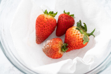 Fresh and Moldy Strawberries in a Glass Bowl on a White Napkin