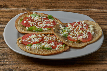 Mexican food. Gordita stuffed with beans, covered with lettuce, tomato, cheese and spicy food.
