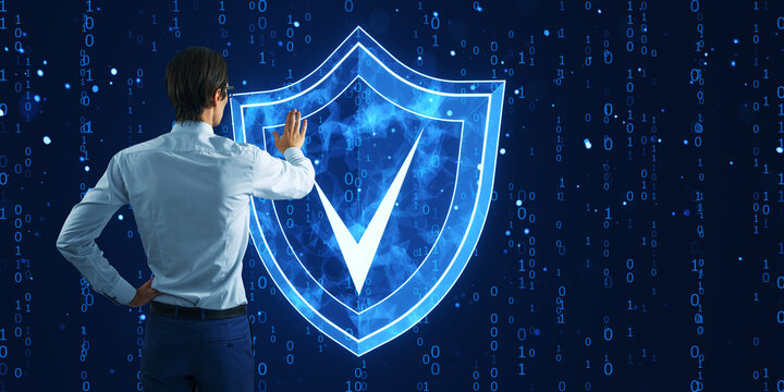 Man interacting with a digital shield on a binary code background, representing cyber security and data protection.