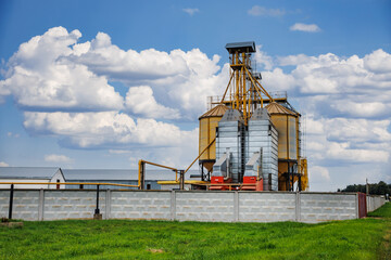 modern granary elevator with silver silos on agro-processing and manufacturing plant for processing drying cleaning and storage of agricultural products, flour, cereals and grain.