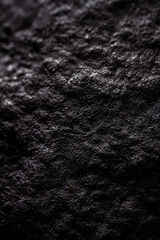 Extreme close up of painted in black handmade paper mache with a structure and rough texture. Paper recycling. Selective focus, shallow depth of field.