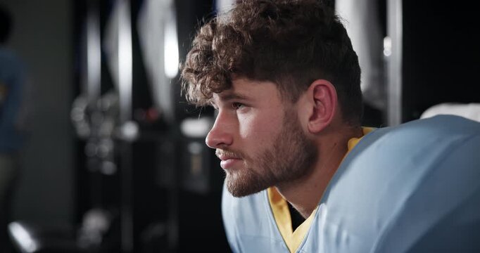 Football, thinking and man in locker room ready for playing in match, game and competition. Sports, athlete and person prepare for training, exercise and workout for fitness, practice and tournament