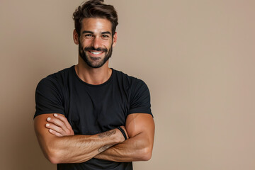 portrait of a happy man in black t-shirt looking into camera over brown background 