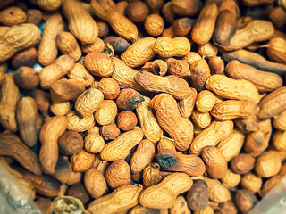 Close-up view from above of shelled peanuts in wooden table