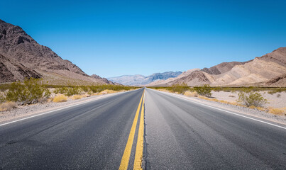 Endless Desert Highway Stretching Towards Distant Mountain Range Under Clear Blue Sky