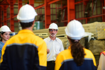 Professional Caucasian manager engineer wearing safety hardhat is training industry worker, workshop factory operator, mechanical engineering team production in heavy industrial manufacture factory.