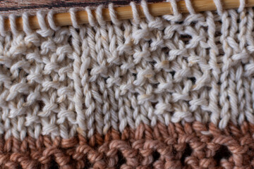 background texture of hand knitting in neutral beige and brown colours 