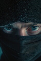 A man with a black scarf covering his face and eyes