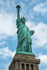 New York, NY, USA - August 4, 2023: Miss Liberty statue closeup, against blue cloudscape