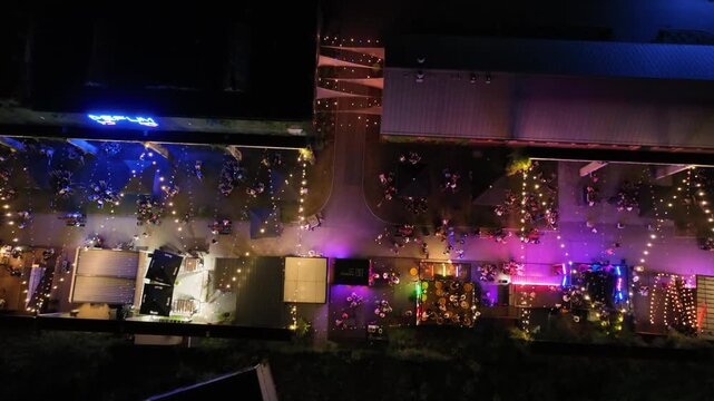 Aerial drone view of summer evening outdoor cinema in the city. The colorful heart of night meetings in the center of a medium-sized city. Night party zone in the city center. Dabrowa Gornicza, Poland