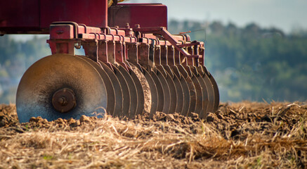 Close up of round tractor disc lades in the dirt on a farm