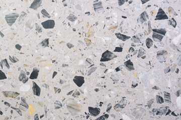 A stone floor with a lot of black and white stones. The floor is very textured and has a lot of different shapes and sizes