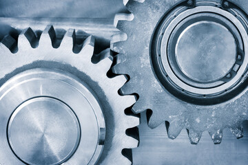 A gear is shown with a ball bearing in the center. The gear is part of a machine and is turning. ndustrial background concept