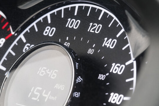 Close-up of car speedometer with digital display showing average speed and time