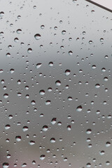 Raindrops on window glass with blurred background creating a serene atmosphere