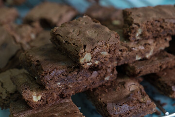 Delicious homemade chocolate brownies with nuts stacked on a cooling rack.
