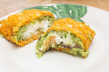 Close-up of two cut pieces, one filled with creamy ricotta cheese and the other with marinated smoked salmon and cream cheese, both wrapped in a baked carrot layer. Healthy food for wellness.