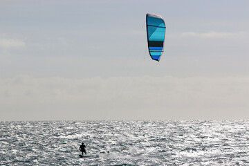 Kitesurfer riding his board in waves