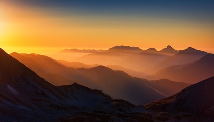 A mountain range silhouetted against a dramatic sunrise sky with golden light illuminating the peaks and valleys