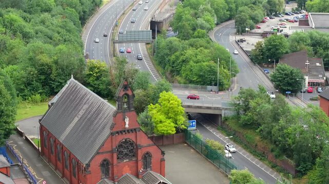 Aerial video of a church in Stockport with M60 outer ring road traffic on the background. 